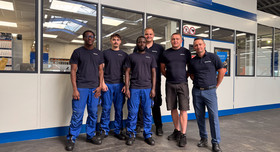 Gruppenfoto in einer Werkhalle: Ausbildungsleiter Irenaeus Jost (rechts) und Ausbilder Sven Fischer (dritter von rechts) mit Auszubildenden von Röchling Industrial am Standort Nentershausen.