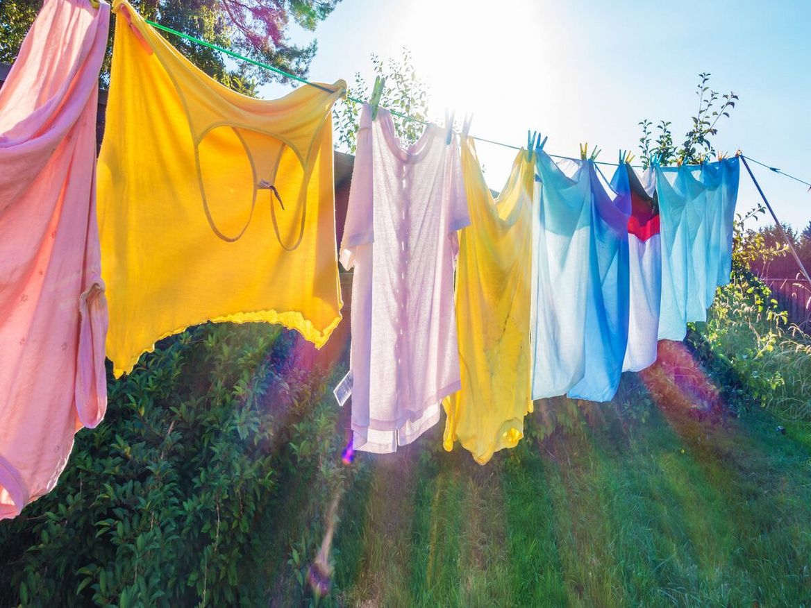 Bunte Wäsche hängt im Sonnenlicht auf der Trockenleine.
