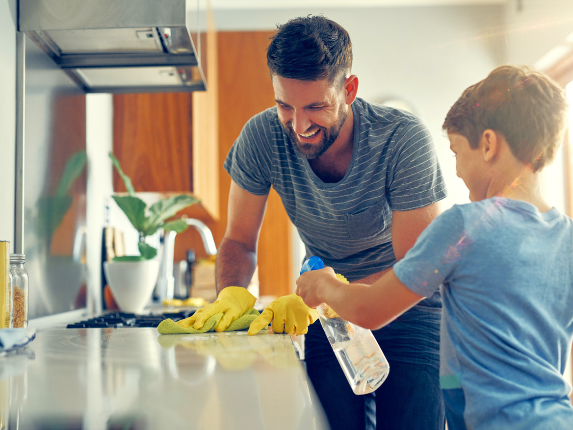 Vater und Sohn beim fröhlichen Küchenputz.