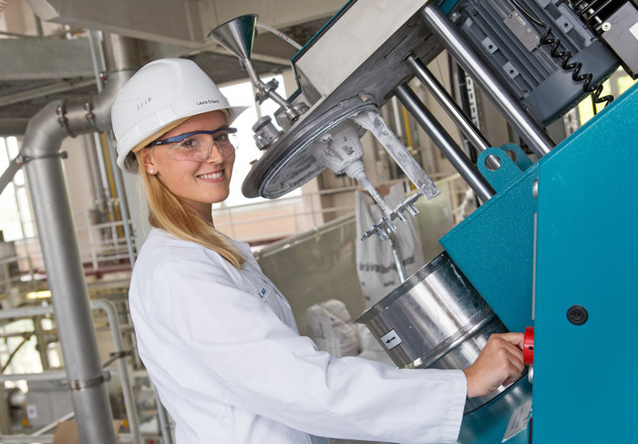 Eine Mitarbeiterin in Schutzkleidung steht im Technikum.