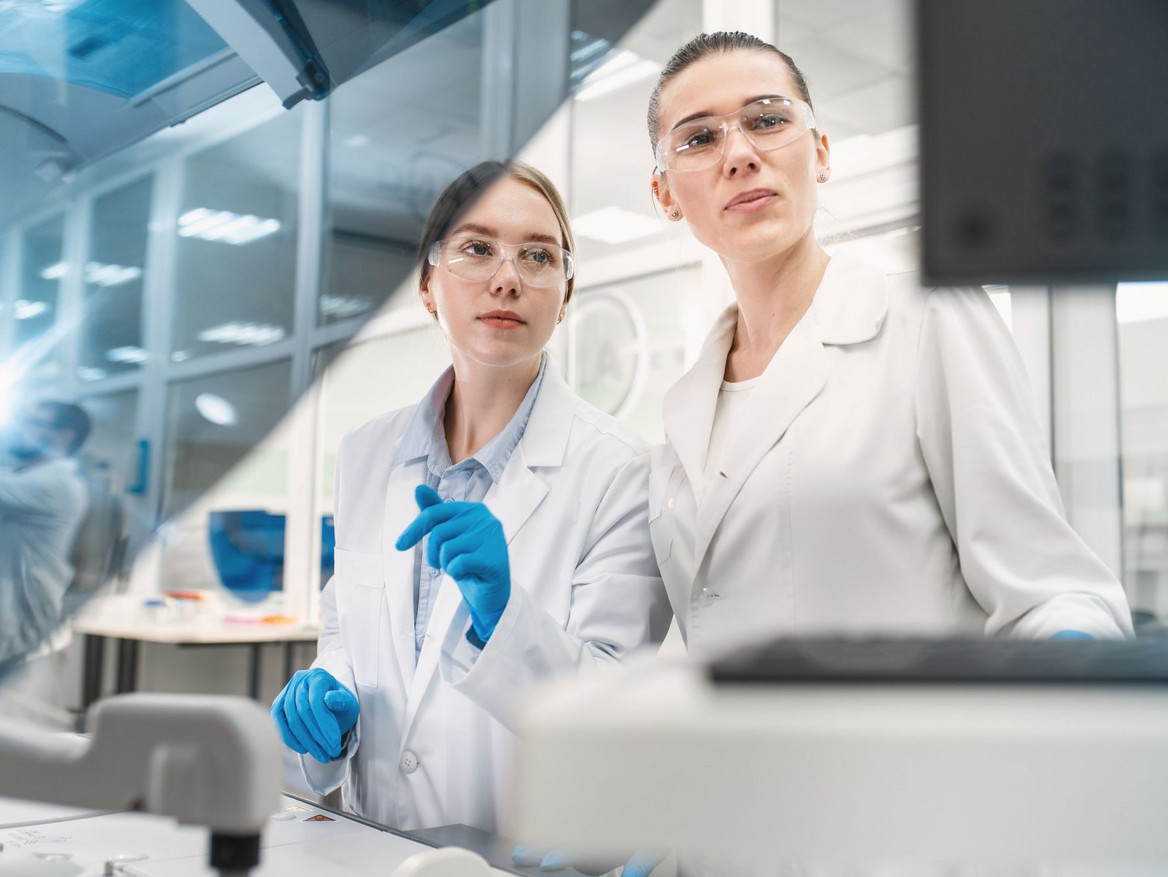 Zwei Wissenschaftlerinnen bei Analysetätigkeiten in einem modernen Labor.