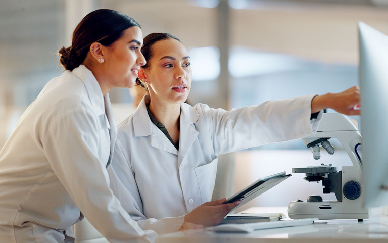 Zwei junge Naturwissenschaftlerin diskutieren am Monitor die digitale Auswertung ihrer Versuchsergebnisse.