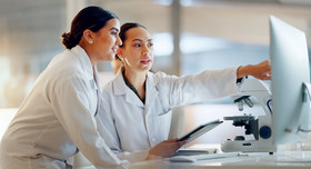 Zwei junge Naturwissenschaftlerin diskutieren am Monitor die digitale Auswertung ihrer Versuchsergebnisse.
