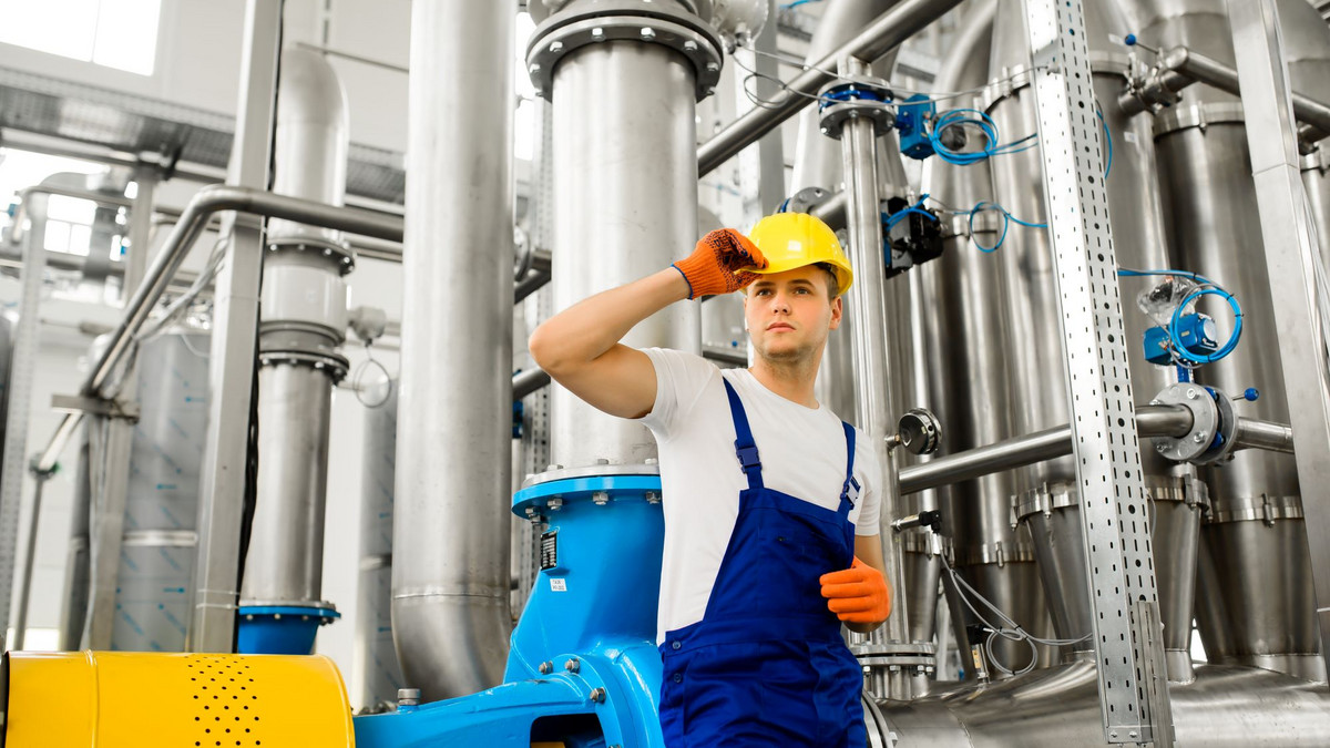 Junger Chemikant vor einer Chemie-Anlage. Foto: Olha - stock.adobe.com