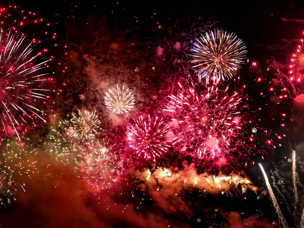 Silvesterfeuerwerk in Rot- und Goldtönen.