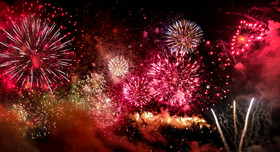 Silvesterfeuerwerk in Rot- und Goldtönen.