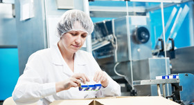 Zufriedene Pharmamitarbeiterin in der Fertigung und Kommissionierung.