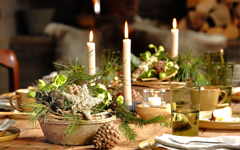 Warme Gold- und Cremetöne Festlich gedeckter Adventstisch mit Kerzen und Naturmaterialien.