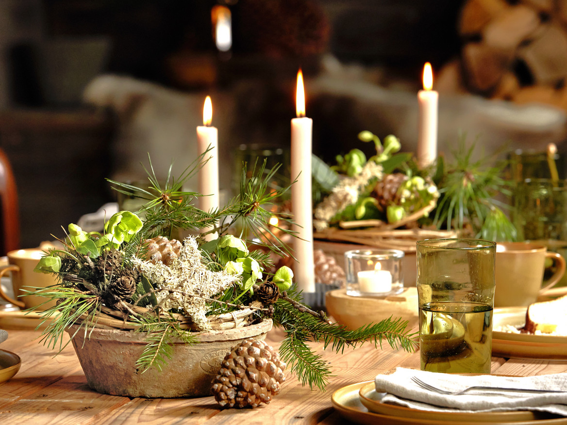 Festlich gedeckter Adventstisch mit Kerzen und Naturmaterialien.