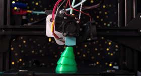 Ein grüner Weihnachtsbaum aus dem 3D-Drucker bekommt seinen letzten Schliff.