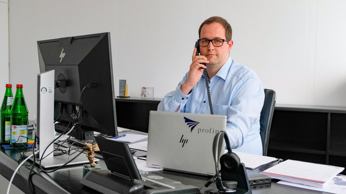 Alexander Franke, Chief Supply Chain Officer bei Profine, bei einem Telefonat an seinem Schreibtisch.