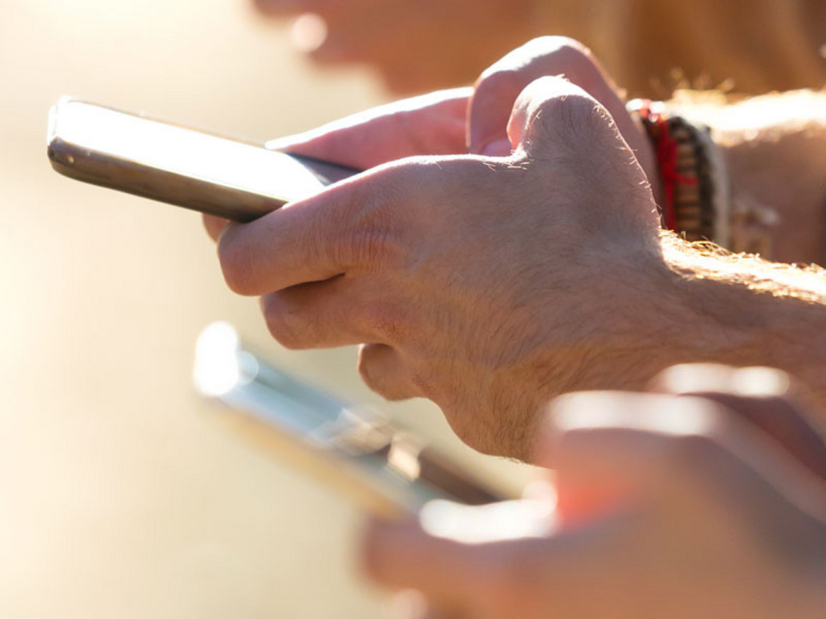 Jugendliche halten Smartphones in den Händen