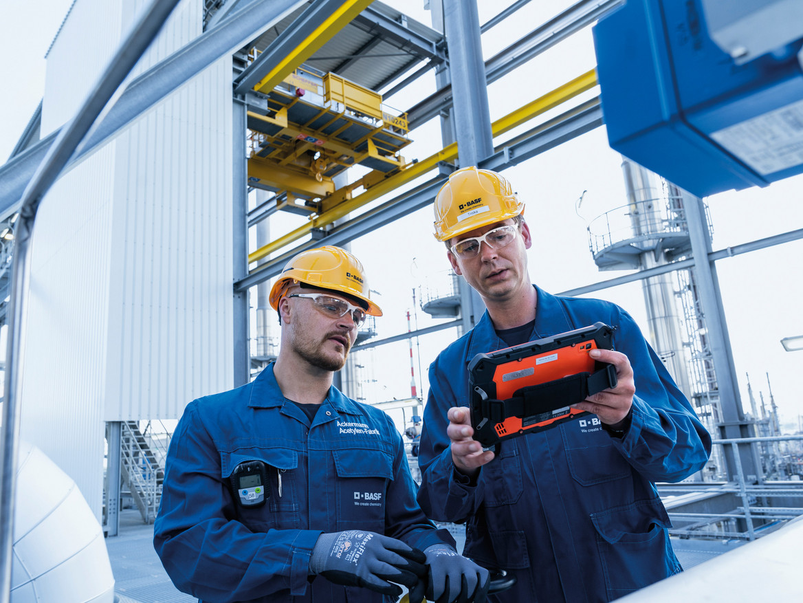 Zwei BASF-Mitarbeiter stehen an einer Anlage.