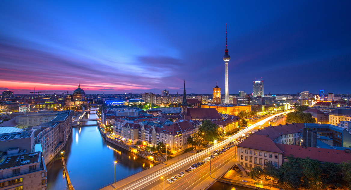 Der Berliner Fernsehturm und die Spree bei dunklem Himmel. 
