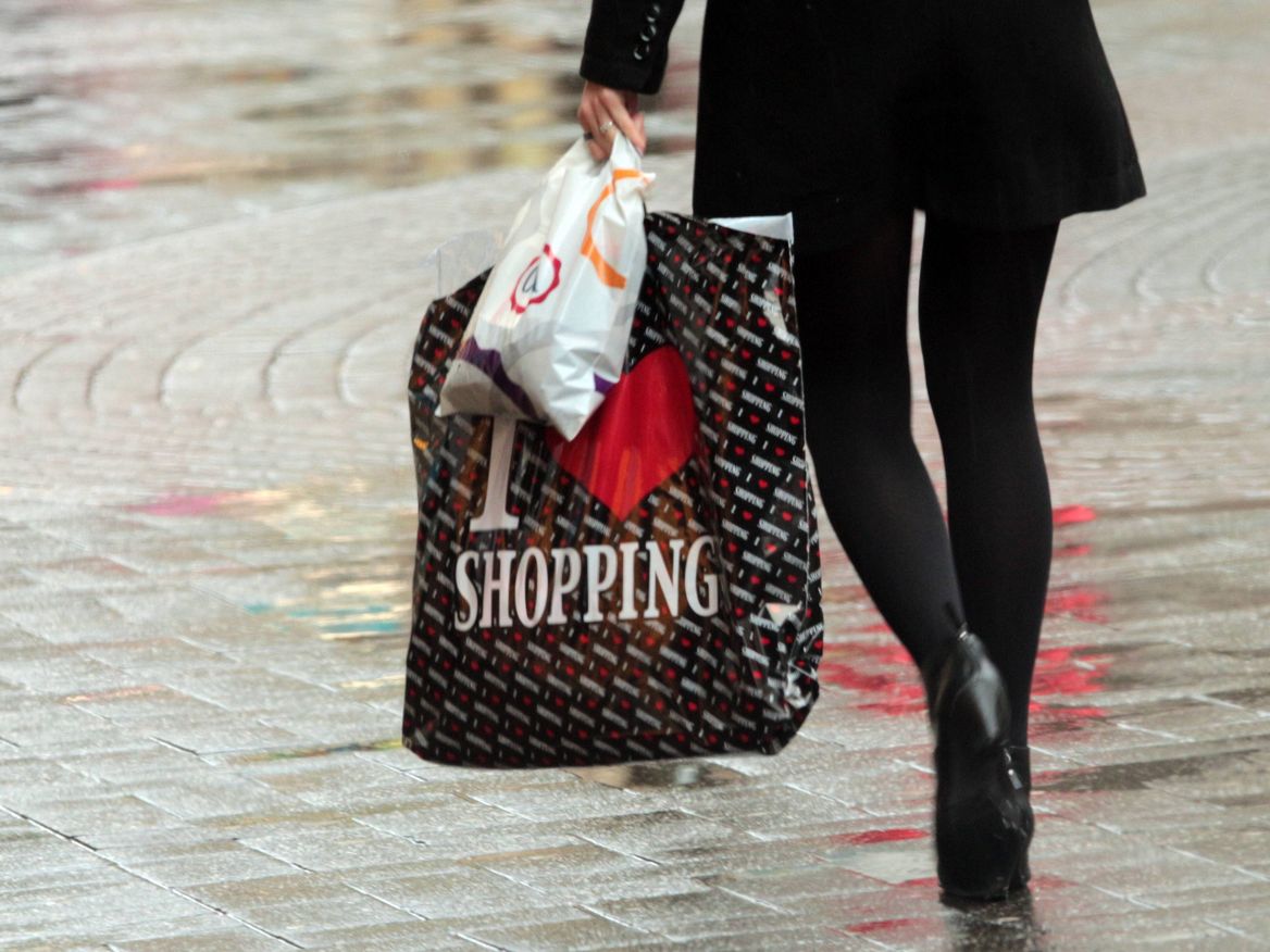 Eine Frau hält Einkaufstüten aus Plastik in den Händen