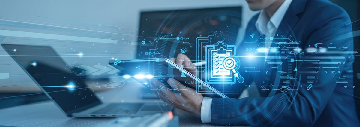 Ein Geschäftsmann wählt anhand eines Tablets und weiterer Monitore einige Kriterien für wichtige Business-Entscheidungen aus. Foto: Shevon/stock.adobe.com