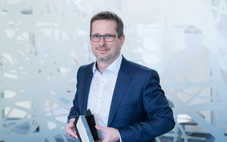 Chemieingenieur Felix Herberg – hier mit einem Brennstoffzellenfilter in der Hand – setzt auf die innovative Technologie. Foto: Freudenberg