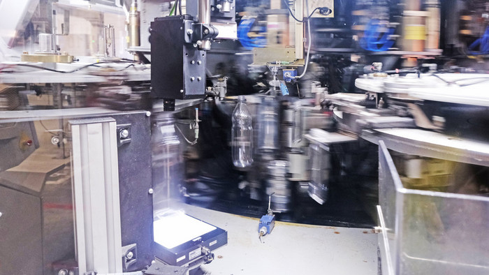 PET-Endprodukt: In der Streckblasmaschine fährt ein Stempel von oben in die aufgeheizten Preforms und pumpt Druckluft hinein. Foto: Wir.Hier./Florian Lang
