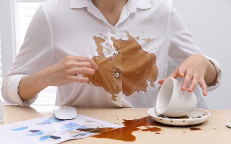 Eine Frau hat eine Tasse Kaffee verschüttet.