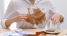Eine Frau hat eine Tasse Kaffee verschüttet.