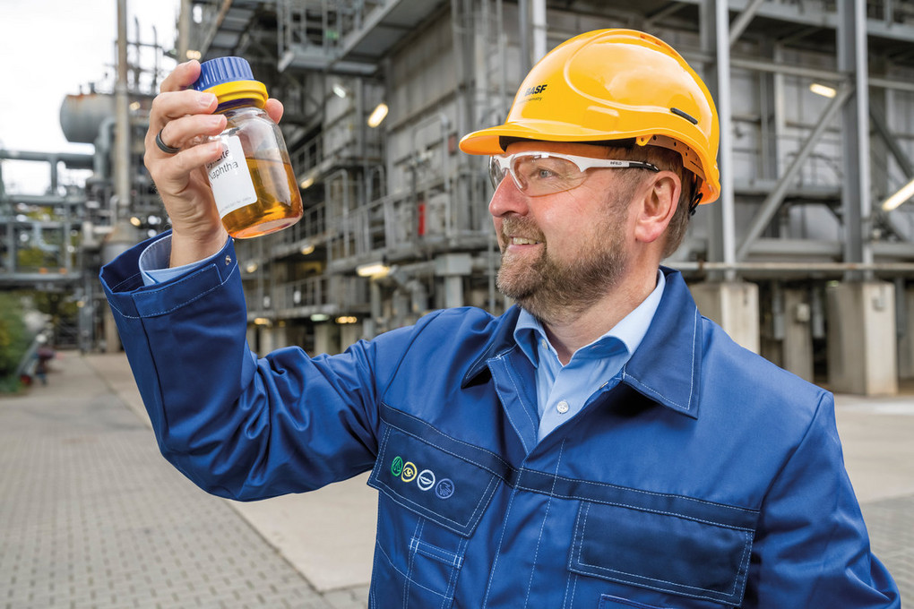 Ein Mitarbeiter der BASF mit einer Probe vor dem Steamcracker