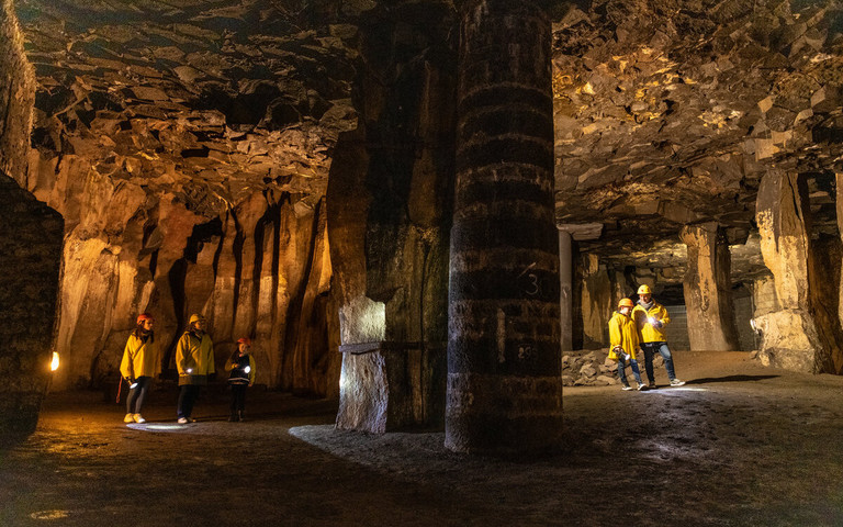 Menschen stehen in einer weitläufigen Höhle