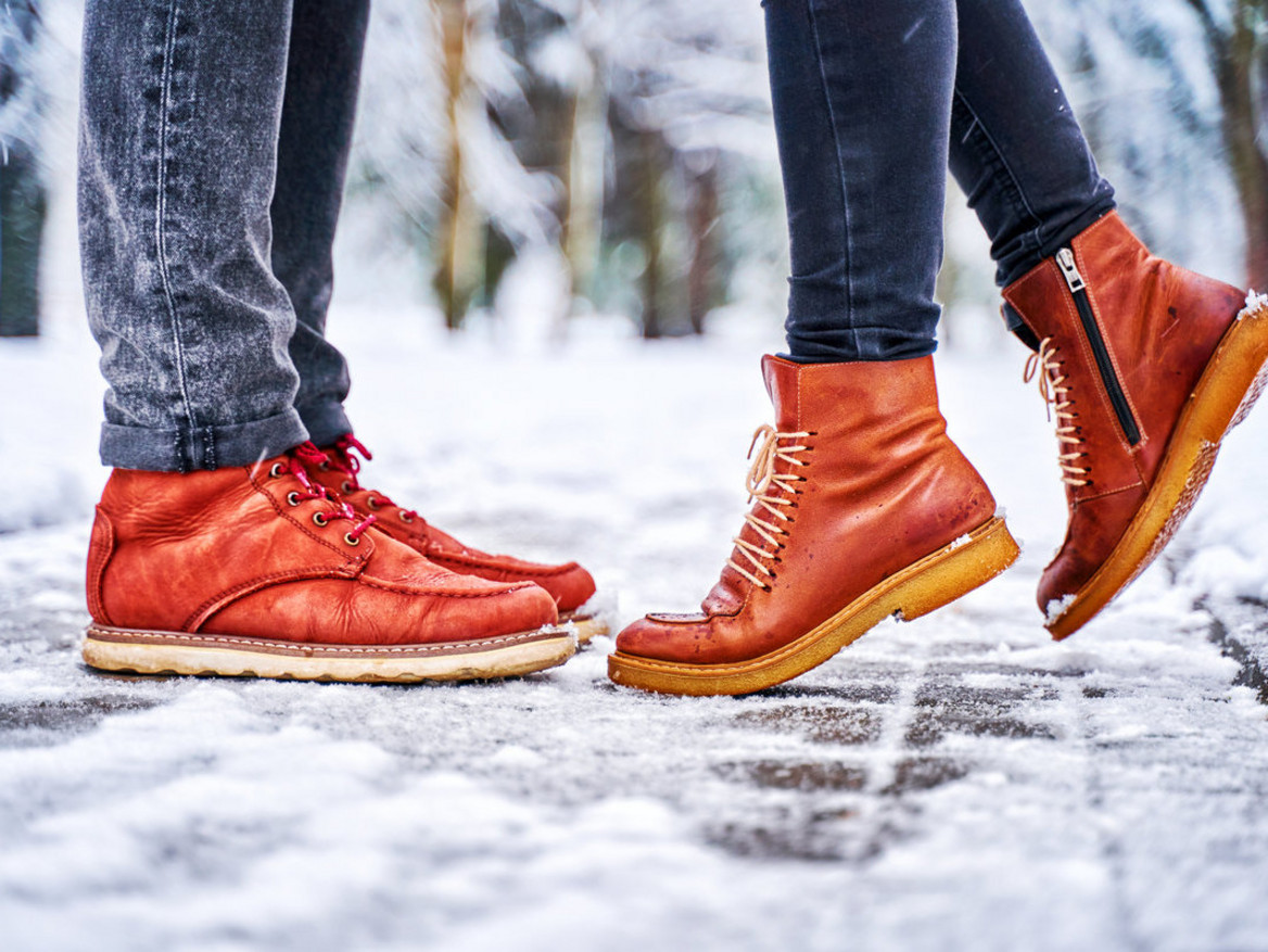 Zwei Menschen in Lederschuhen stehen im Schnee