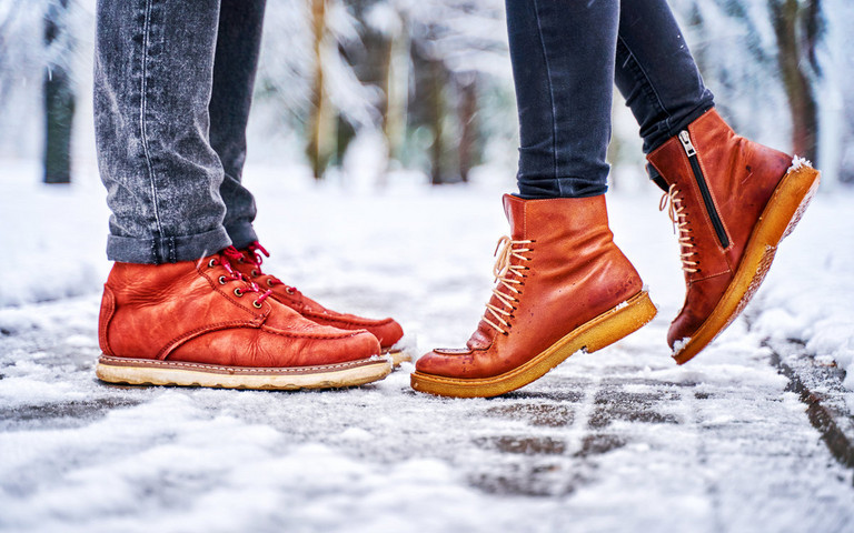 Zwei Menschen in Lederschuhen stehen im Schnee