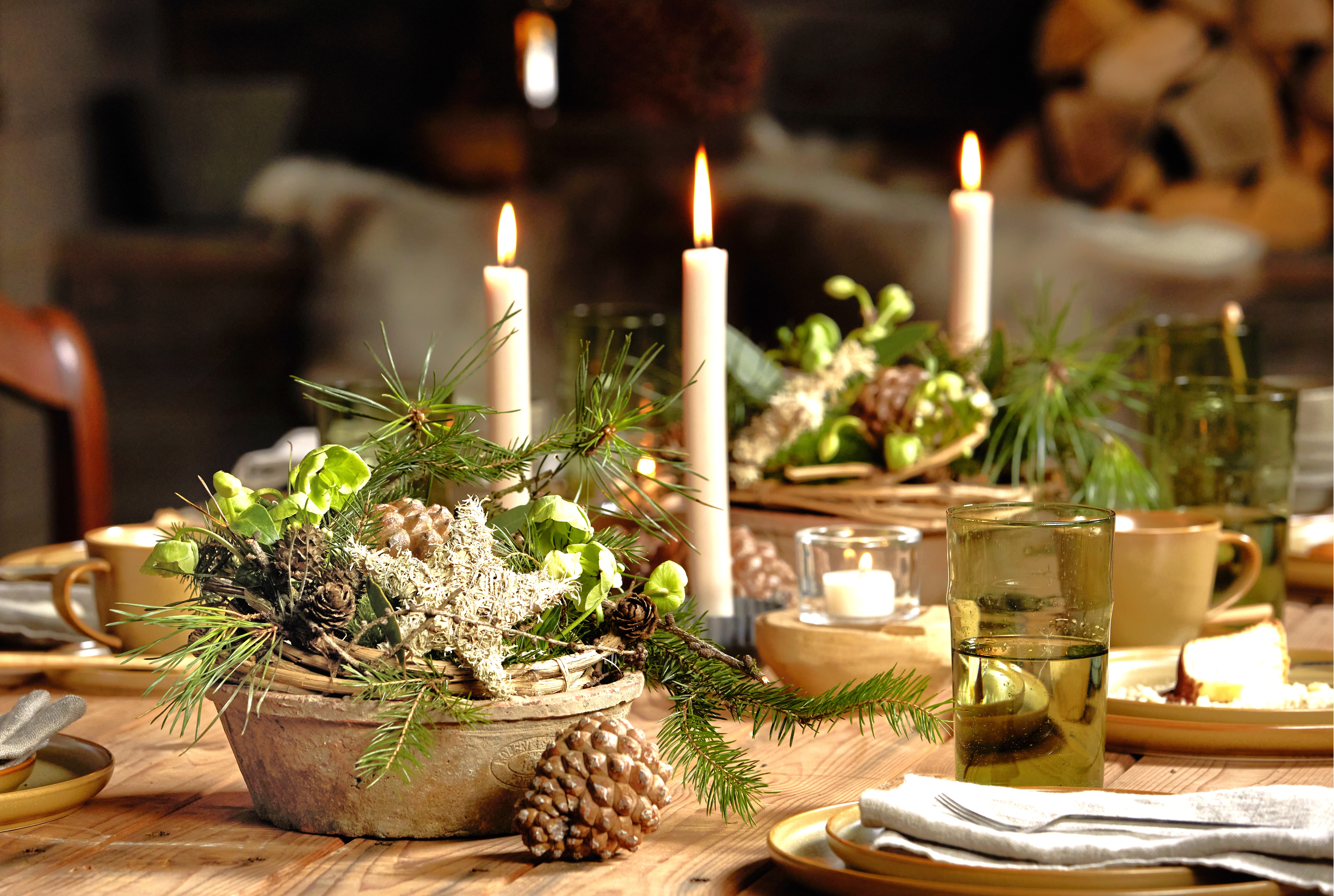 Festlich gedeckter Adventstisch mit Kerzen und Naturmaterialien.