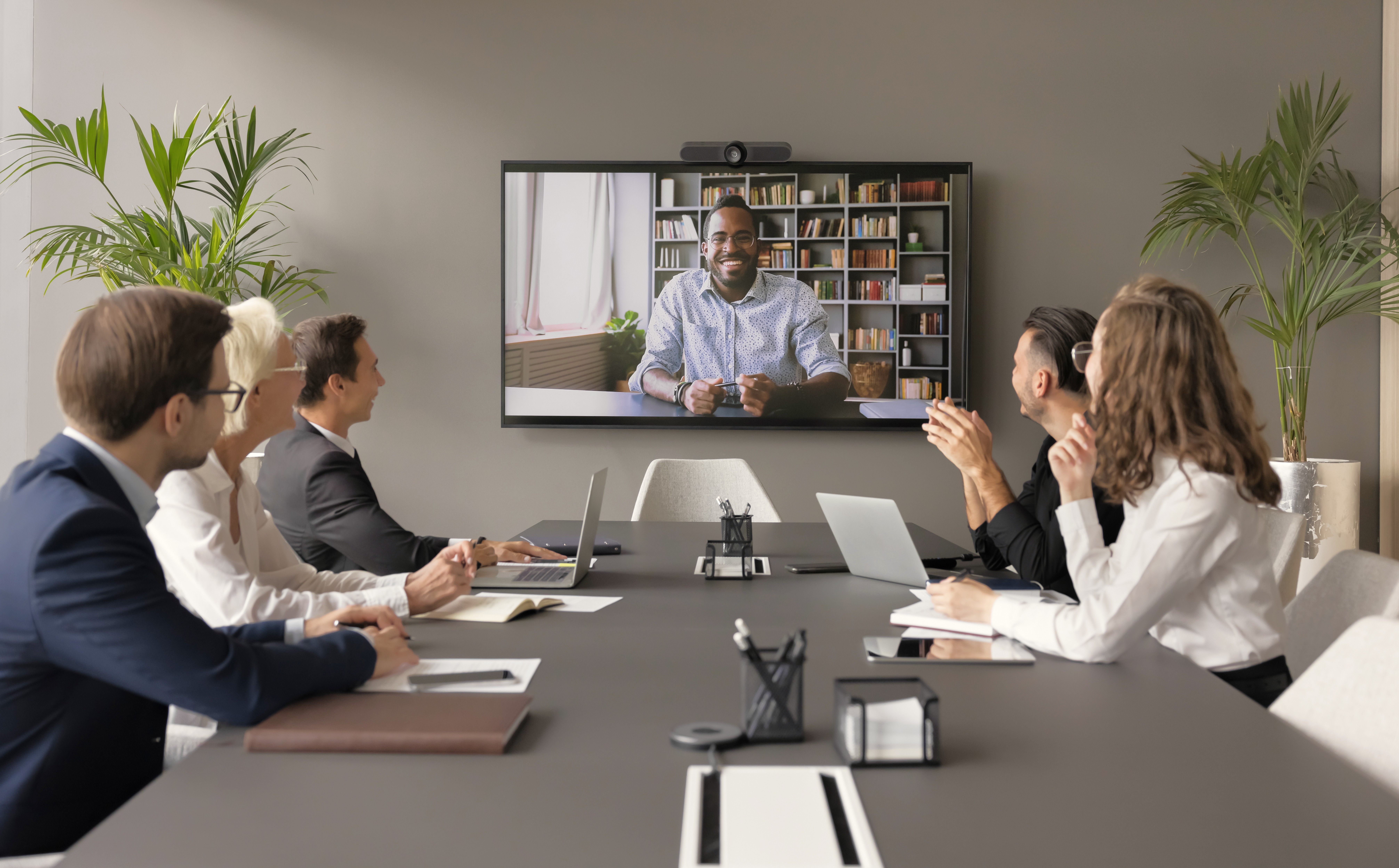 Internationaler Bewerber stellt sich einem freundlichen Team per Videocall vor.