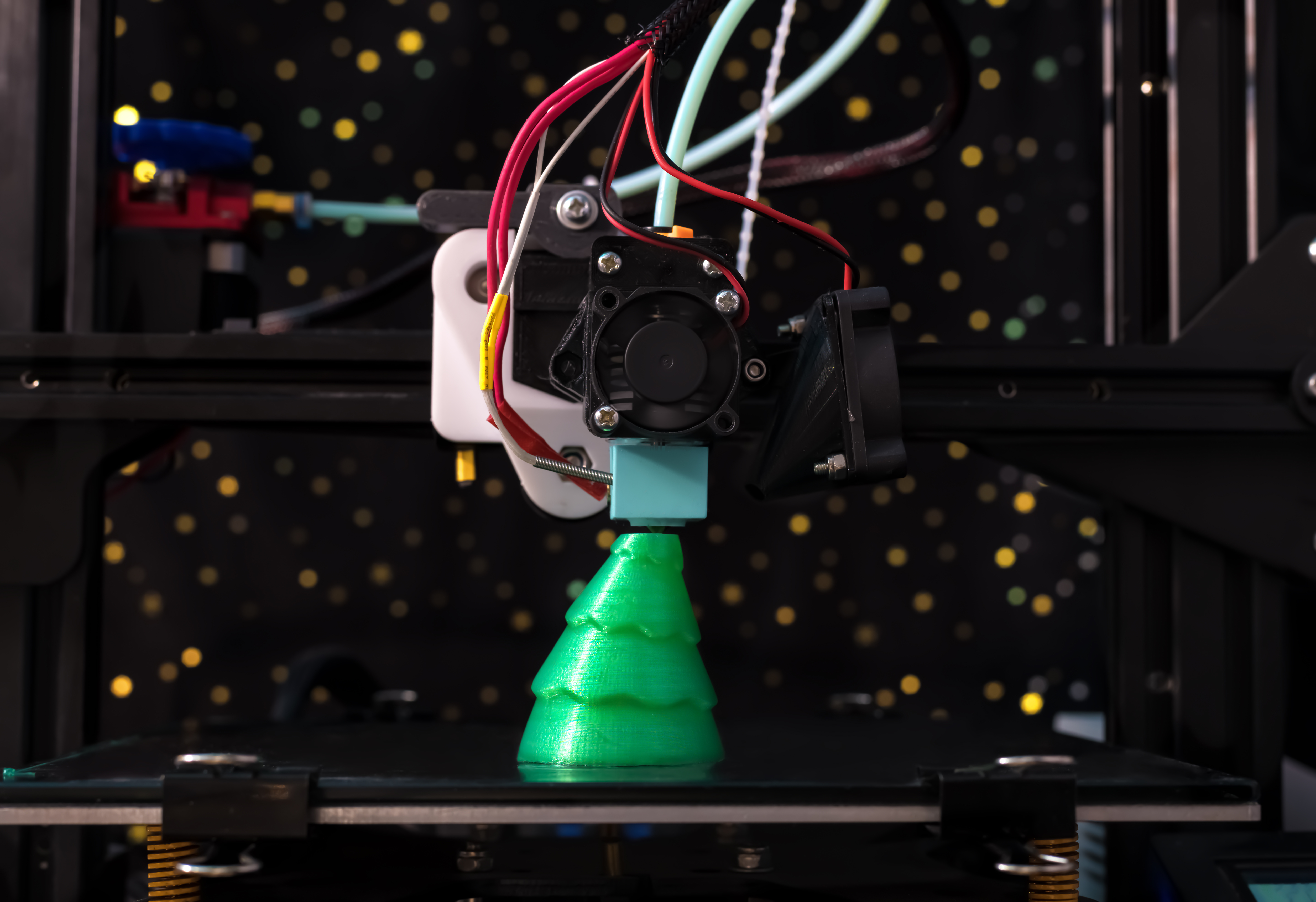 Ein grüner Weihnachtsbaum aus dem 3D-Drucker bekommt seinen letzten Schliff.