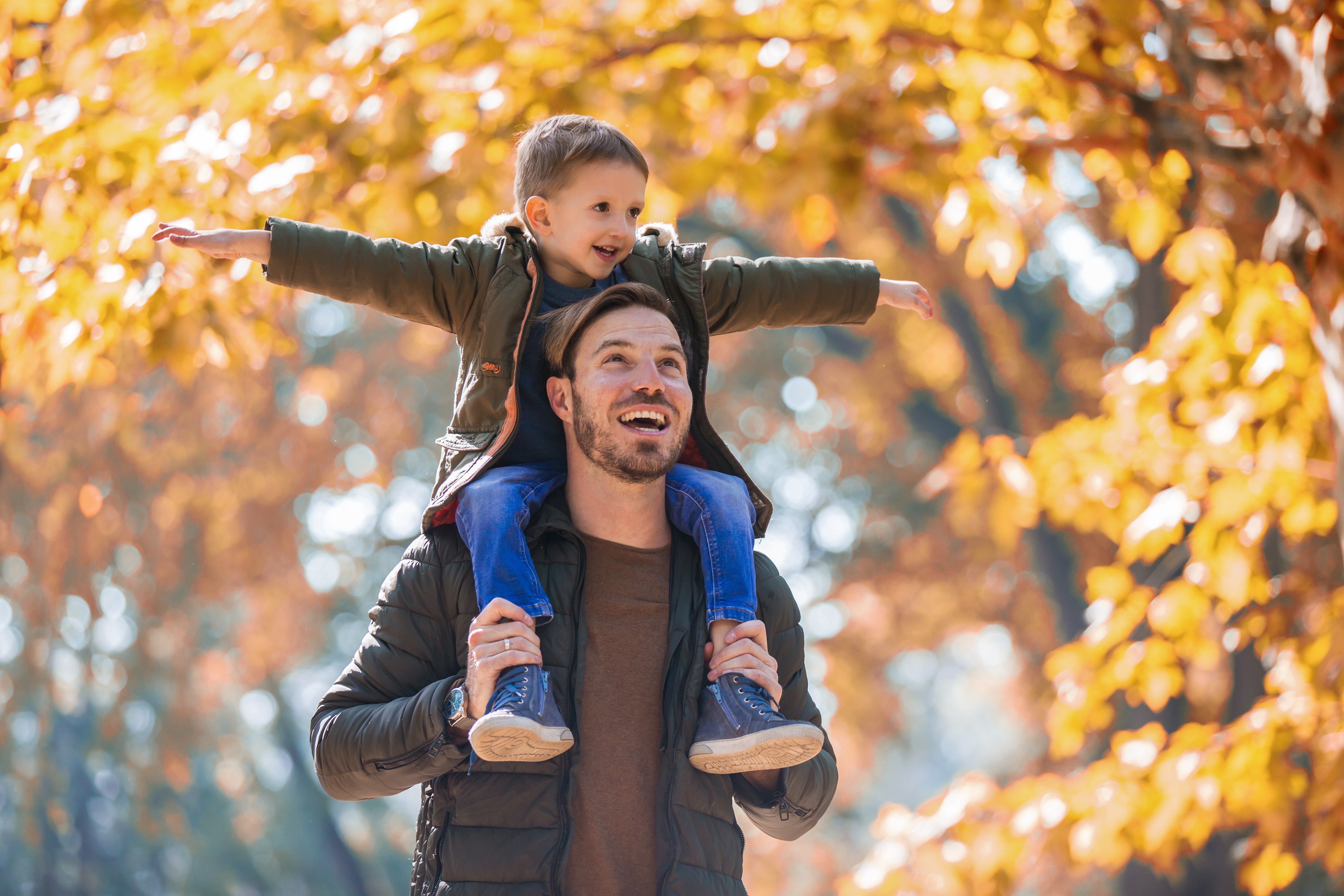 Vater und Sohn haben Spaß in einem herbstlichen Park.