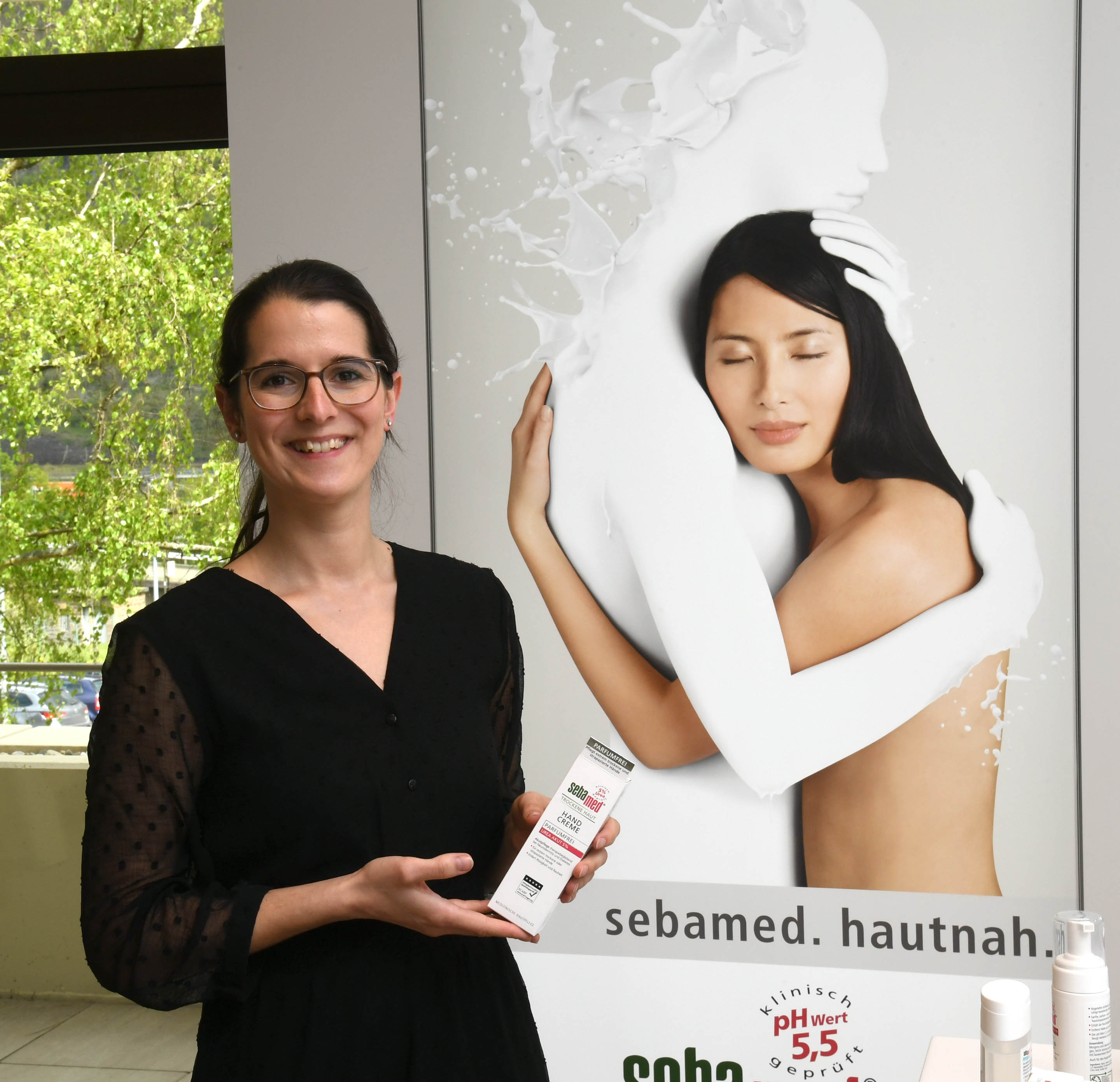 Christine Liesenfeld steht vor einem Sebamed-Plakat.